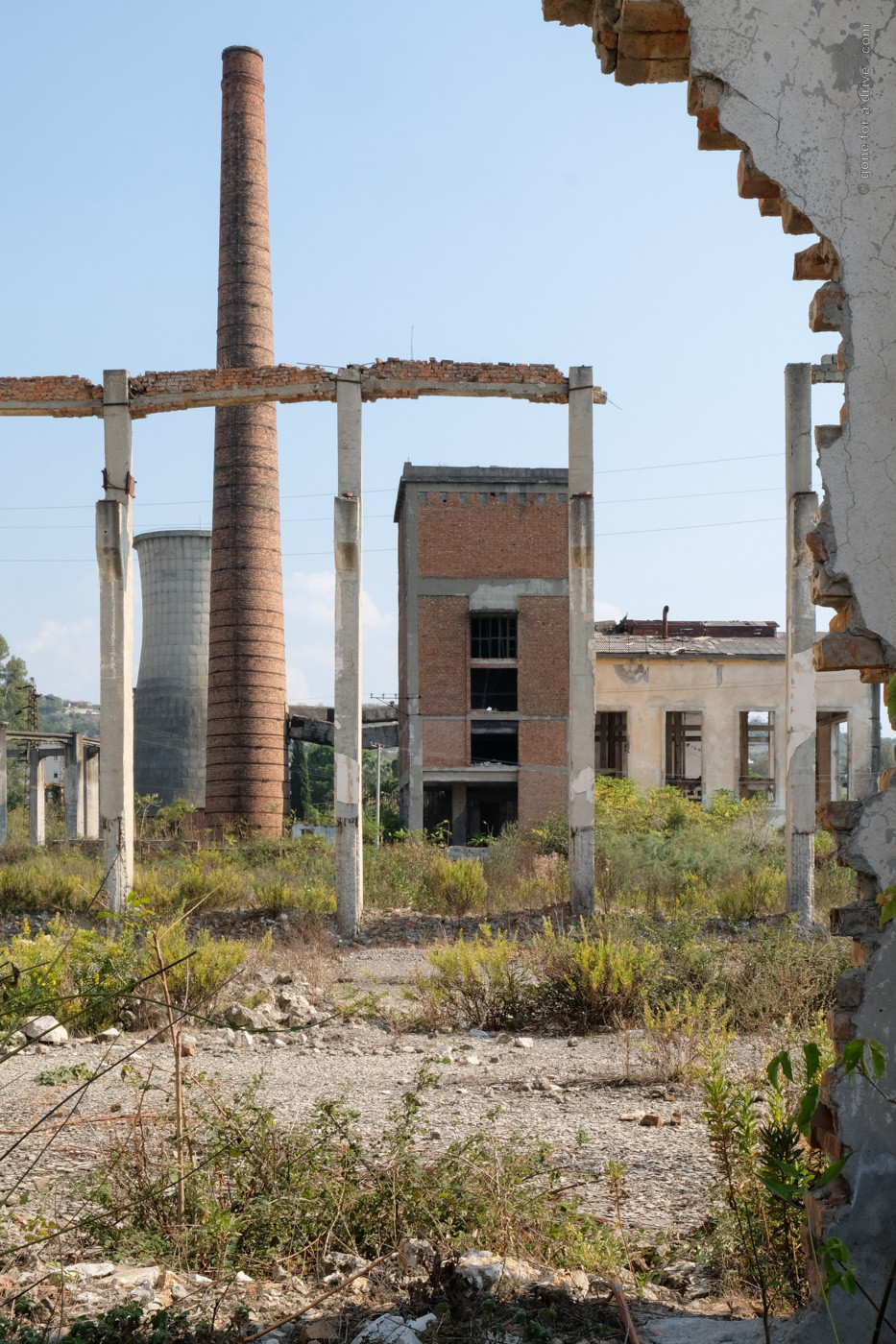 Verfallene Fabrikanlangen und ein Kühlturm in Kucova, Albanien.